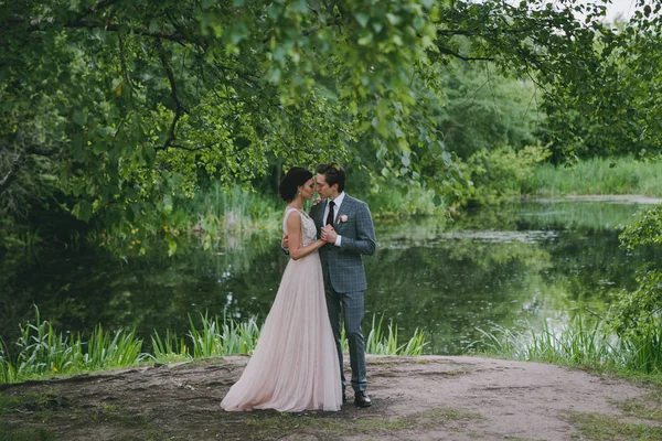 A girl and a man are hugging in a park near a pond — Stock Photo, Image