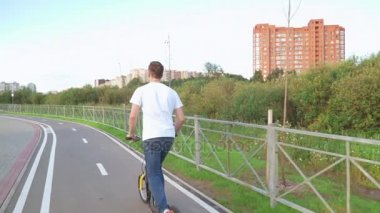 Parkta bir adam scooter kullanıyor.