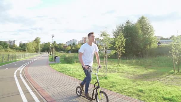 Un hombre está montando una moto en el parque — Vídeo de stock