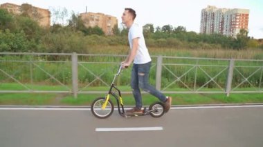 Parkta bir adam scooter kullanıyor.