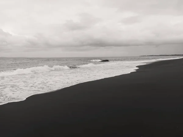 Der Strand mit schwarzem vulkanischen Sand Stockfoto