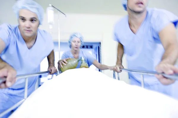 廊下で患者と病院 ガーニーを押して緊急チーム — ストック写真