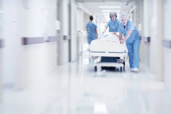 Γιατροί Που Πιέζει Κρεβάτι Του Στο Νοσοκομείο Ασθενή Μέσω Διαδρόμου — Φωτογραφία Αρχείου