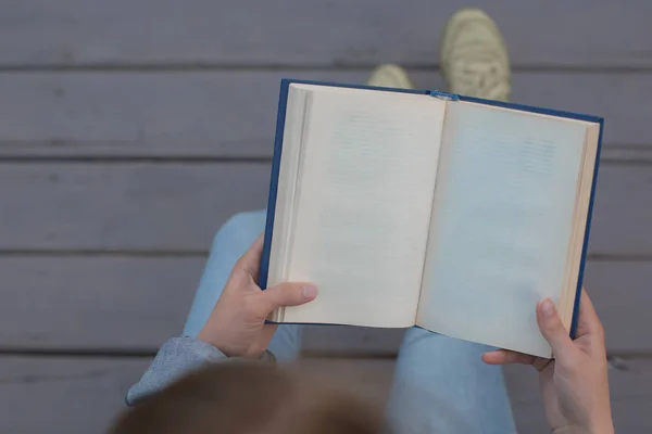 person teenager read book outside