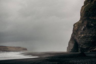 black sand basalt beach and cliffs clipart