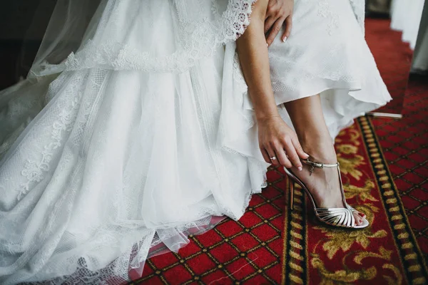 bride putting shoe on foot