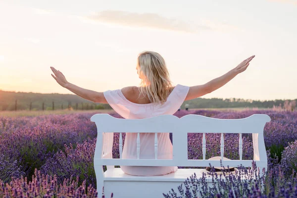 Beautiful blone hair woman watching sunset at lavender field.