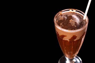 Siyah arka planda bardakta lezzetli bir milkshake.