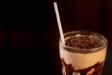 Siyah arka planda bardakta lezzetli bir milkshake.