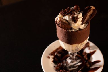 Siyah arka planda bardakta lezzetli bir milkshake.