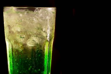 Siyah arkaplanda yeşil alkolol kokteyli izole edilmiş.
