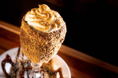 Ahşap arka planda bardakta lezzetli bir milkshake.