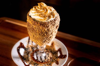 Ahşap arka planda bardakta lezzetli bir milkshake.