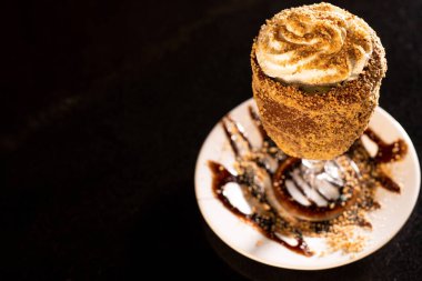 Siyah arka planda bardakta lezzetli bir milkshake.