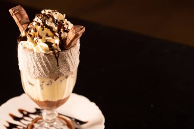 Siyah arka planda bardakta lezzetli bir milkshake.