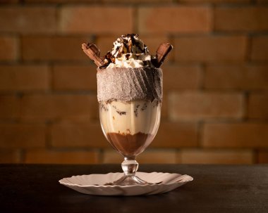 Siyah arka planda bardakta lezzetli bir milkshake.