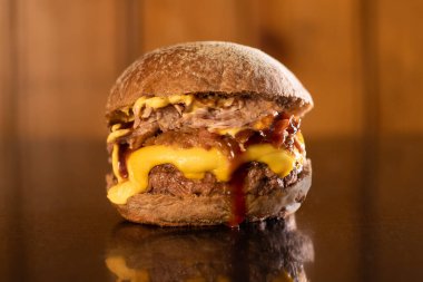 Ahşap arka planda servis edilen taze ev yapımı hamburger.