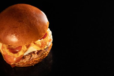 Siyah arka planda taze lezzetli bir burger.