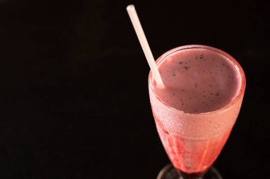 Siyah arka planda bardakta lezzetli bir milkshake.