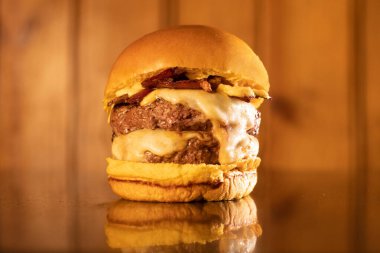 Ahşap arka planda servis edilen taze ev yapımı hamburger.