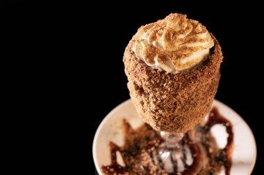 Siyah arka planda bardakta lezzetli bir milkshake.