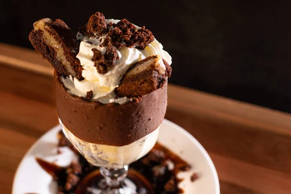 Ahşap arka planda bardakta lezzetli bir milkshake.