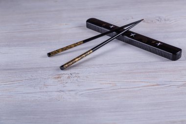 Beyaz ahşap arka planda Japon suşi çubukları. Kopyalama alanı olan üst görünüm