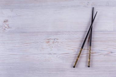 Beyaz ahşap arka planda Japon suşi çubukları. Kopyalama alanı olan üst görünüm