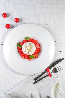 Olgun domatesli lezzetli caprese salatası ve taze fesleğen yapraklı mozzarella peyniri. İtalyan yemeği..
