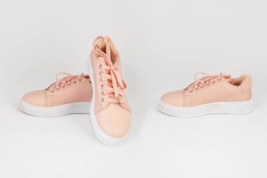Pembe spor ayakkabıları beyaz arka planda ve ön tarafta izole edilmiş.