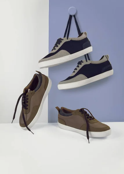 Набор обуви кроссовки висит на сине-белом фоне и передний вид настроение снимок — стоковое фото