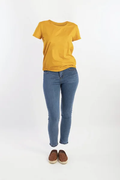 Vêtements vides invisible sexy Femme portant t-shirt jaune et jeans serrés avec des chaussures posant vue de face Photo De Stock