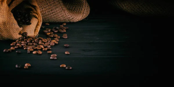 Grãos de café em um fundo de madeira escura com espaço para o seu texto — Fotografia de Stock