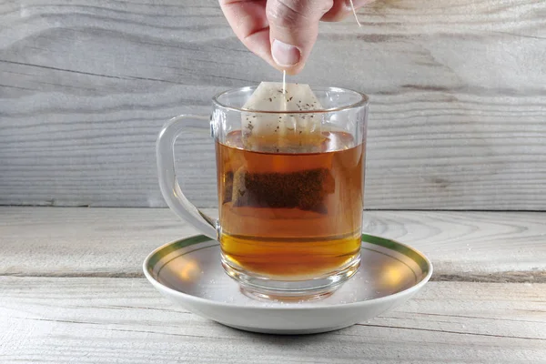 En mugg med en sked och en påse med te är fylld med kokande vatten — Stockfoto