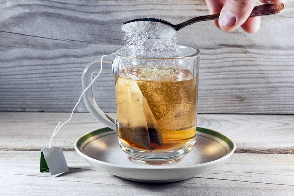 Häll socker i en mugg te — Stockfoto