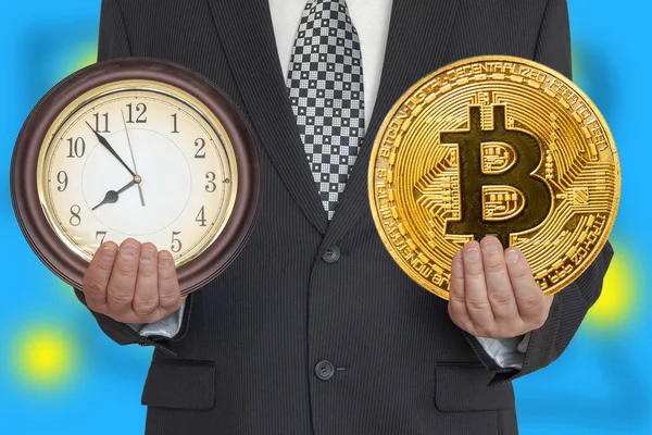 Zaman bitcoin. Bir adam bir saat ve bitcoin elinde tutar