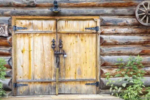 Entrada para a forja com um portão de madeira — Fotografia de Stock