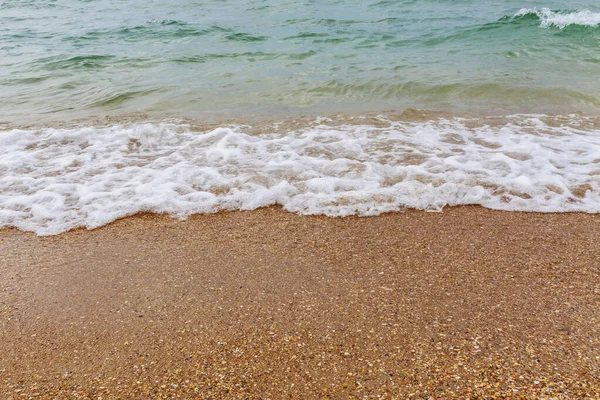 Kumlu kıyıda bir koşu dalgası.