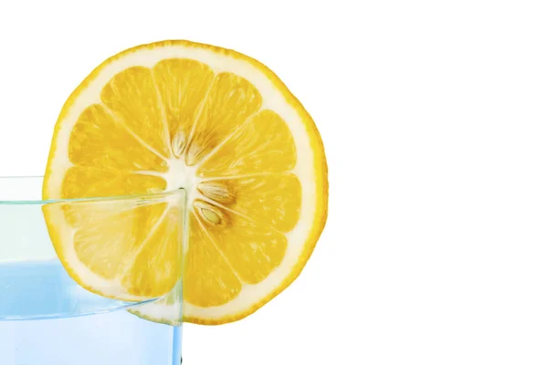 Limone con un bicchiere d'acqua su fondo bianco . — Foto Stock