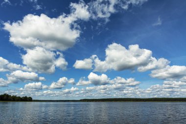 Günbegün büyük bir gölün üzerinde yaz bulutları.