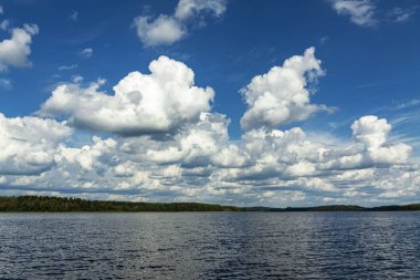 Günbegün büyük bir gölün üzerinde yaz bulutları.