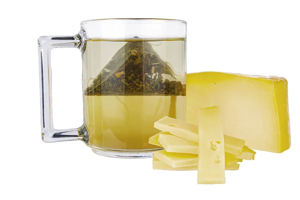 Uma caneca com chá verde de um saco, ao lado dele é queijo. Tudo sobre um fundo branco . — Fotografia de Stock