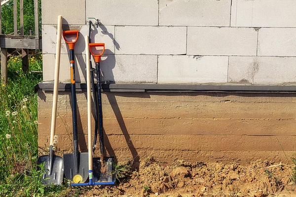 Bir tuğla evin arka planına karşı kürek çeşitleri.