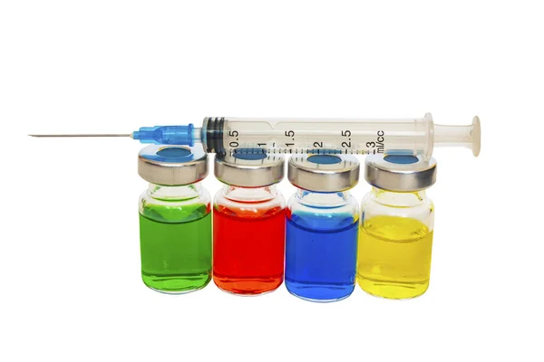 The syringe lies on the vessels with colored liquid. — Stock Photo, Image