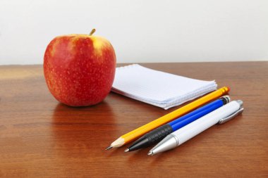 Elma dolmakalem not defteri masanın üzerinde.