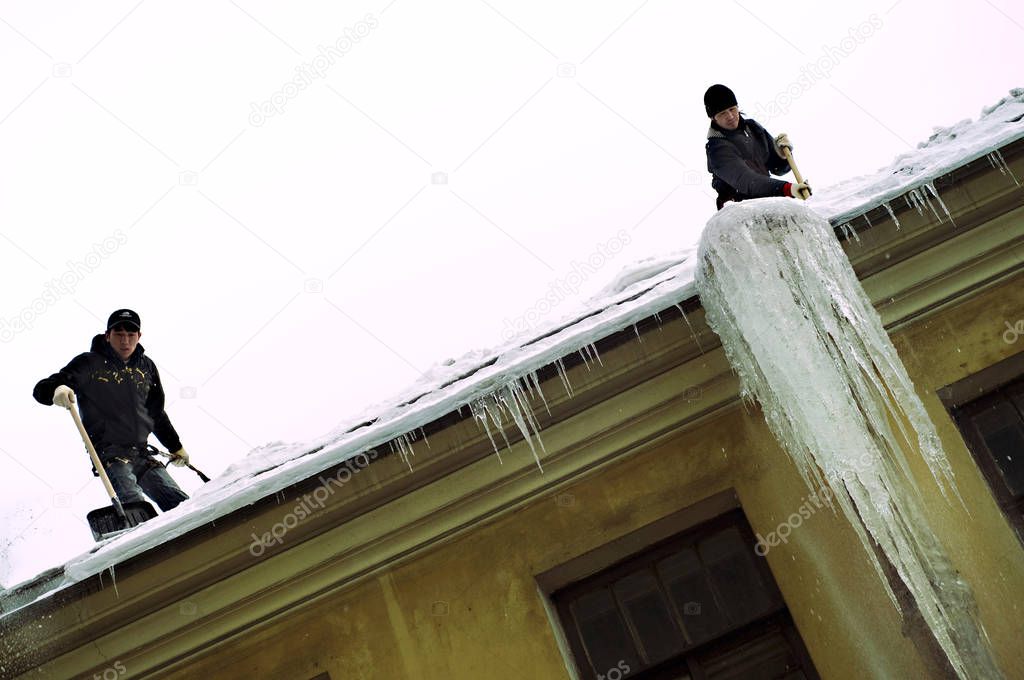 icicles on a yellow house on the roof hang down fall melt on windows, Russia, St. Petersburg, yard-well