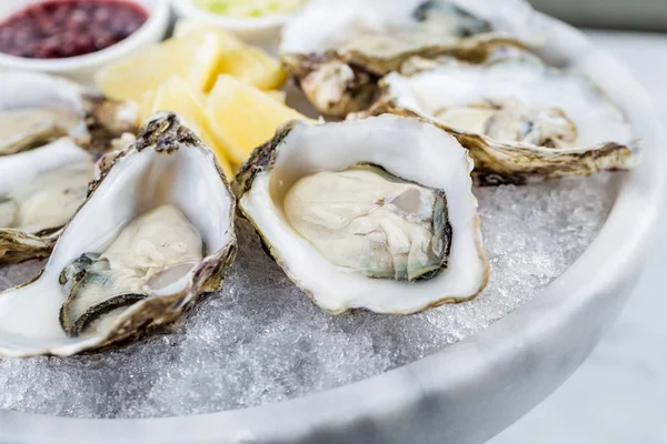 Fresh oysters platter with sauce and lemon — Stock Photo, Image