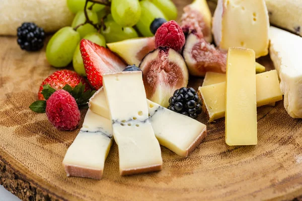 Piatto di formaggio con uva da pane e fragole — Foto Stock