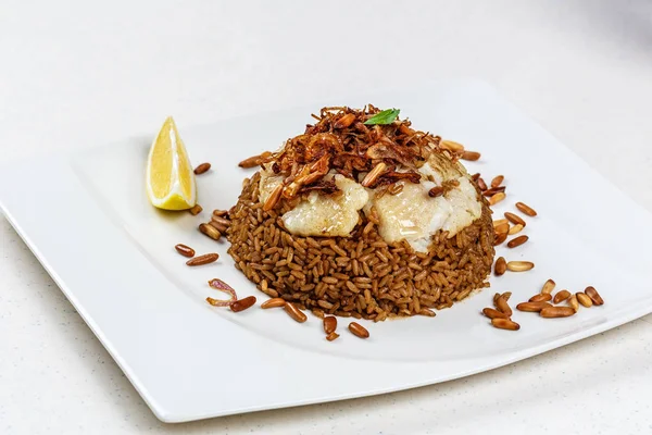 Peixe tradicional do Oriente Médio e arroz frito com pinhões fritos — Fotografia de Stock