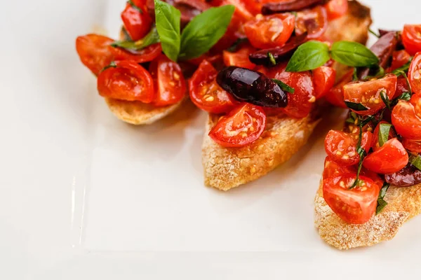 Bruschetta italiana com tomate picado, manjericão e azeitona — Fotografia de Stock